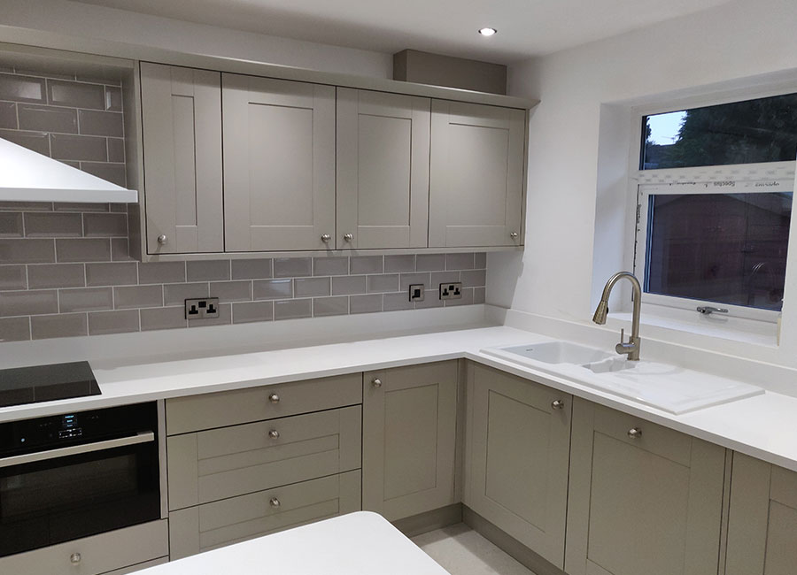 Cream coloured kitchen with grey tiles, fitted in Cheshire